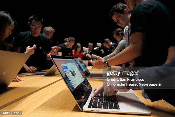 Guests try out the Touch Bar on the updated version of the MacBook Pro laptop at Apple headquarters in Cupertino, Calif. On Thursday, Oct. 27, 2016.