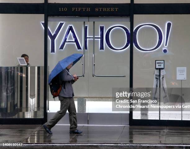 Man uses his smartphone while walking past Yahoo offices on Fifth Street in San Francisco, Calif. On Thursday, Dec. 15, 2016. The tech giant revealed...