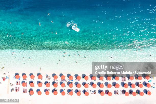 overhead view of beach umbrellas on white sand beach, greece - greece aerial stock pictures, royalty-free photos & images