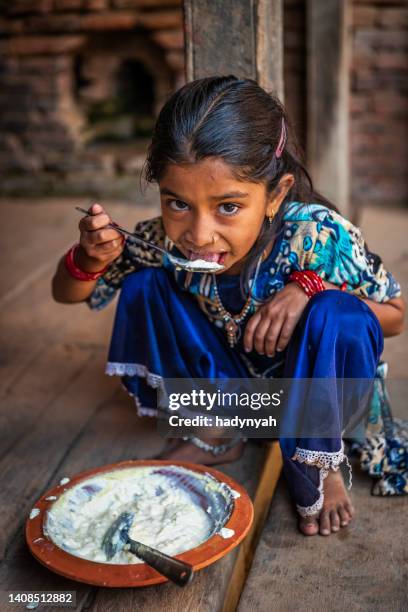 nepalesisches kleines mädchen, das juju dhau aus einem tontopf isst, durbar square, bhaktapur - yoghurt pot stock-fotos und bilder