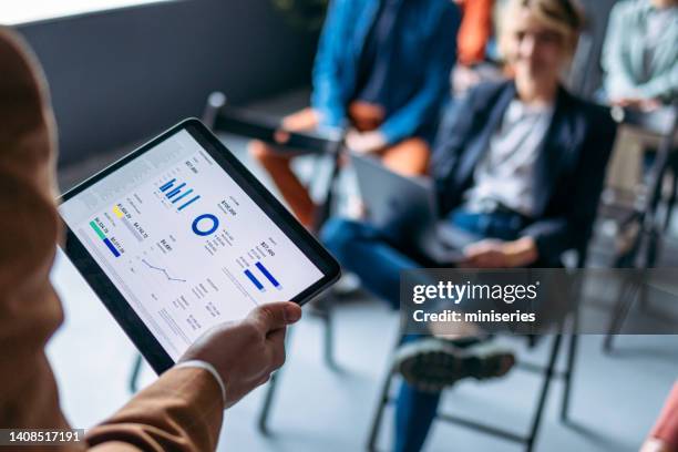 unrecognizable presenter holding a digital tablet with business graph on an education event - attending seminar stock pictures, royalty-free photos & images