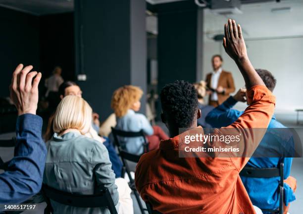 business peoples volunteers to answer a question during a seminar - meeting attendees stock pictures, royalty-free photos & images