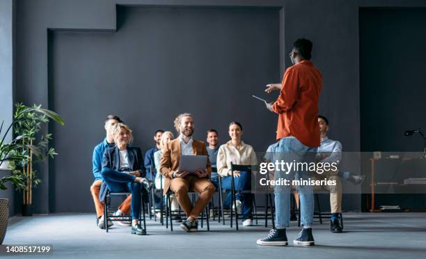 unrecognizable business man talking and pointing to audience during a q and a session - 20 to 35 year old in class stock pictures, royalty-free photos & images