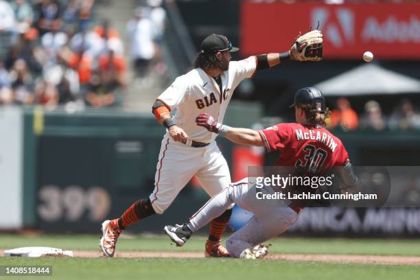Jake McCarthy of the Arizona Diamondbacks slides in safe at second base ahead of the tag by Brandon Crawford of the San Francisco Giants in the top...