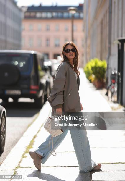 Anna Winter is seen wearing Balenciaga Rubber Pool slide sandals in beige, Source Unknown wide leg denim jeans and cropped denim top, Bottega Veneta...