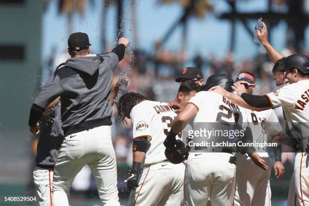 Brandon Crawford of the San Francisco Giants celebrates with teammates after hitting a walk-off single in the bottom of the ninth inning to defeat...