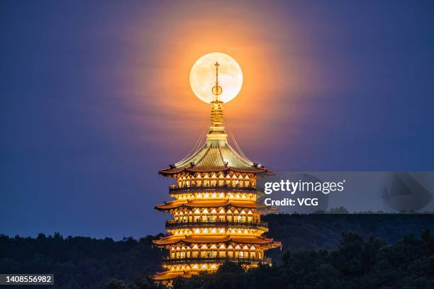 The full moon rises over the Leifeng Pagoda on July 13, 2022 in Hangzhou, Zhejiang Province of China.