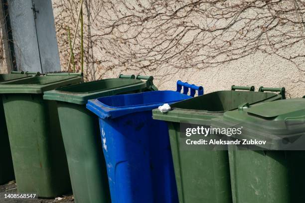 plastic garbage cans or dumpsters, tanks on wheels for moving and transporting, stand in a row on the street. the concept of environmental protection, sustainable lifestyle. recycling of garbage. - skip the line stock pictures, royalty-free photos & images
