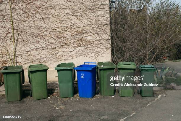 plastic garbage cans or dumpsters, tanks on wheels for moving and transporting, stand in a row on the street. the concept of environmental protection, sustainable lifestyle. recycling of garbage. - wheelie bin stock pictures, royalty-free photos & images