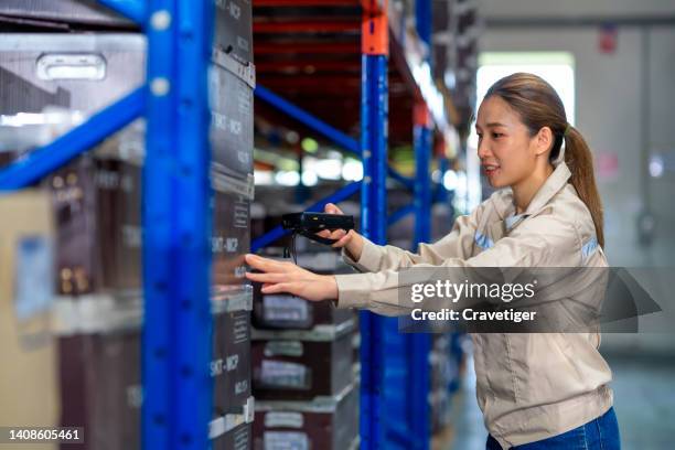 asian female warehouse supervisor scanning goods in cardboard box with bar code reader into inventory system in the warehouse.inventory tracking is powerful in warehouse management - receiving check stock pictures, royalty-free photos & images