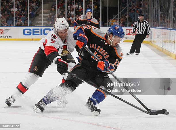 Josh Bailey of the New York Islanders and Milan Michalek of the Ottawa Senators battle for the puck at Nassau Veterans Memorial Coliseum on February...