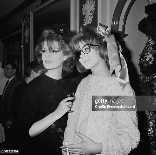 British fashion model Paulene Stone, holding a drinking glass, and British socialite and fashion model Liese Deniz , wearing sunglasses with only...