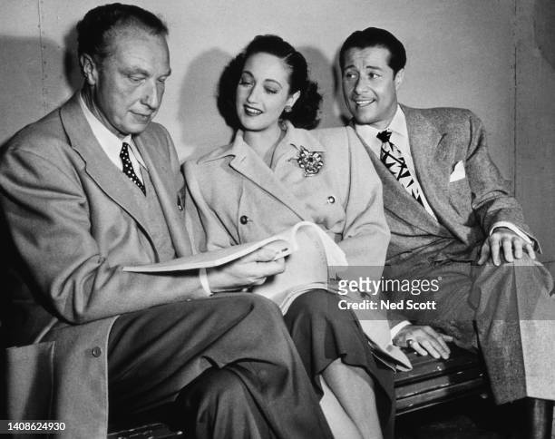 German film director, Douglas Sirk with actors Dorothy Lamour and Don Ameche during rehearsals for the musical comedy, 'Slightly French', Los...