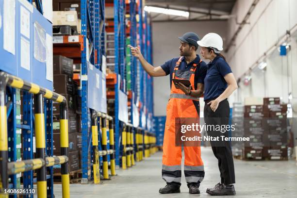 warehouse stock movement in the inventory management system. foreman and manager having a discussion at the distribution warehouse. they are monitoring the movement of goods. - trabajador de almacén fotografías e imágenes de stock