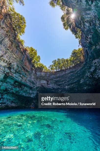 crystal clear water inside the idyllic melissani cave, kefalonia - crystal caves stockfoto's en -beelden