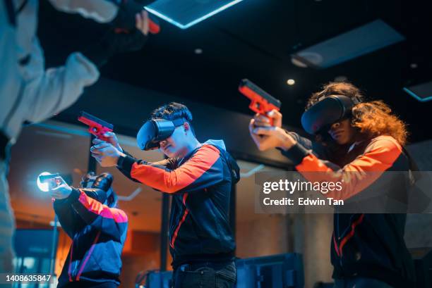 2 asiatische esports-teams, die ein vr-shooter-videospiel spielen, treten im großen finale auf der bühne gegeneinander an.  videospiel championship arena. cyber games turnier event - abfeuern stock-fotos und bilder