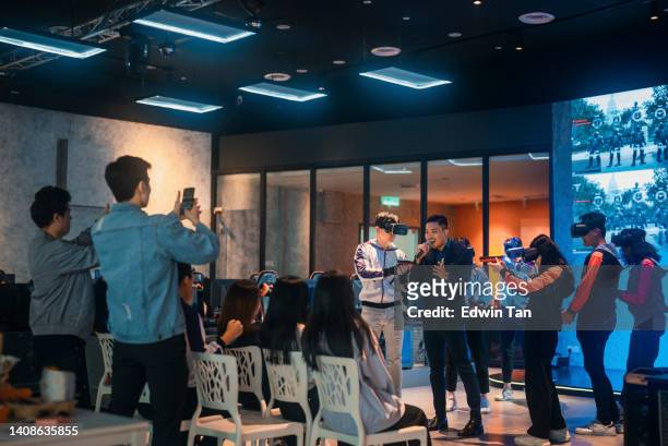 el maestro de ceremonias anfitrión de asian game presenta a 2 equipos asiáticos de esports que juegan videojuegos de disparos de realidad virtual compitiendo entre sí en la gran final en el escenario - match lighting equipment fotografías e imágenes de stock