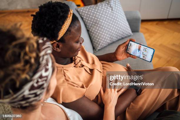 pregnant lesbian couple consulting with their doctor - doctor zoom stock pictures, royalty-free photos & images