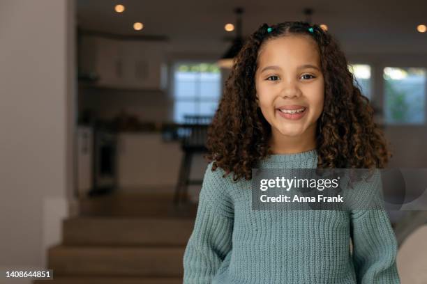 portrait of a happy little girl at home. - smirk stock pictures, royalty-free photos & images