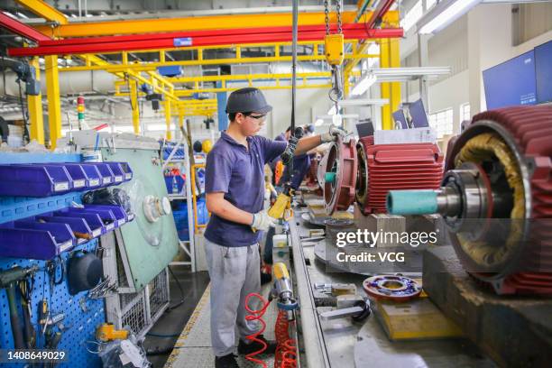 An employee works on the production line of motors at Weg Electric Motor Manufacturing Co., Ltd. On July 14, 2022 in Nantong, Jiangsu Province of...