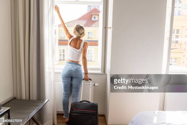 young woman checking in hotel room - guest room stock pictures, royalty-free photos & images