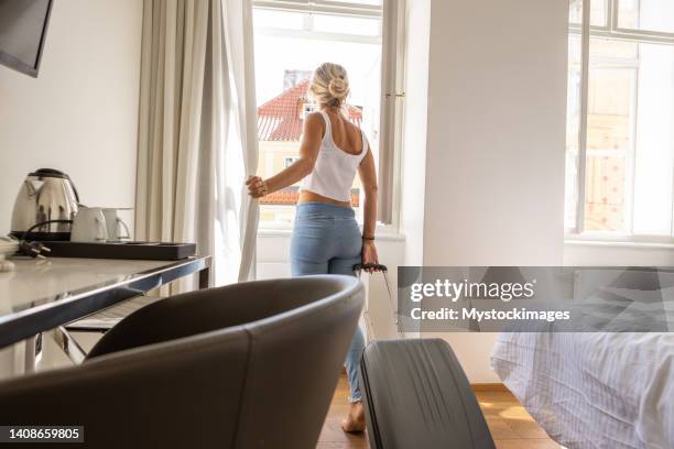 junge frau, die im hotelzimmer eincheckt - checking in at hotel stock-fotos und bilder