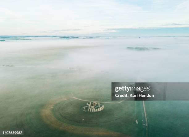 an aerial view of stonehenge, england in the mist - stonehenge stock-fotos und bilder