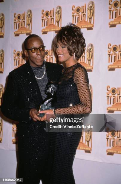 Whitney Houston poses with Lifetime Achievement Award beside Bobby Brown at the 12th Annual Soul Train Music Awards in Los Angeles, California,...