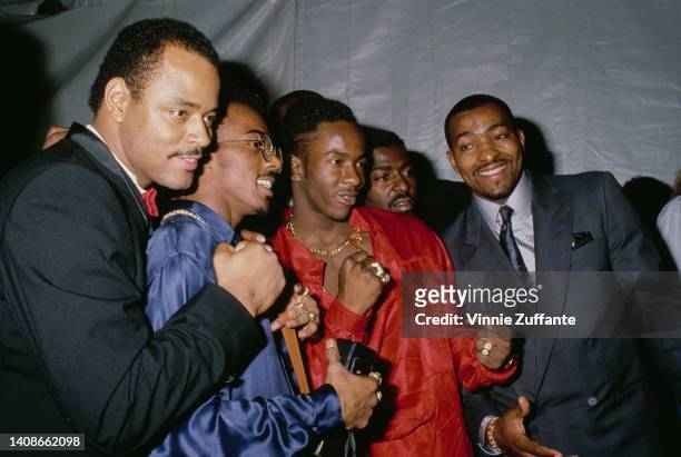 Bobby Brown wears a red leather suit amongst other members of the New Edition band in the United States, circa 1989.