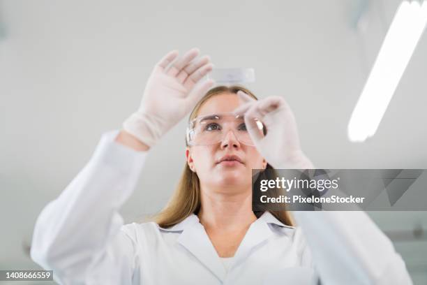 scientist working in laboratory for visual analyze the sample in microscope slide. - scientific sample stock pictures, royalty-free photos & images