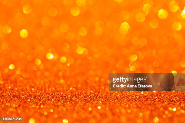 orange background made of sequins and lights. holiday concept. copy space for your design. selective focus - fond orange photos et images de collection