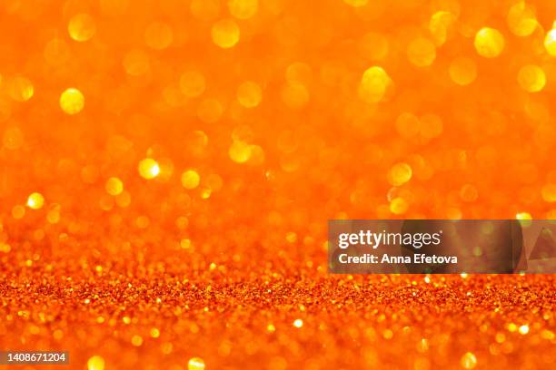 orange background made of sequins and lights. holiday concept. copy space for your design. selective focus - sequin stock pictures, royalty-free photos & images