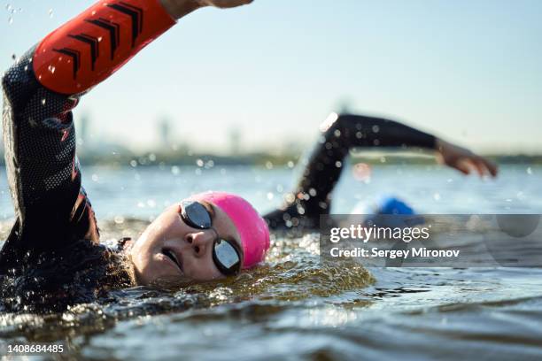 swimmers in open water. - triathlon swim stock pictures, royalty-free photos & images