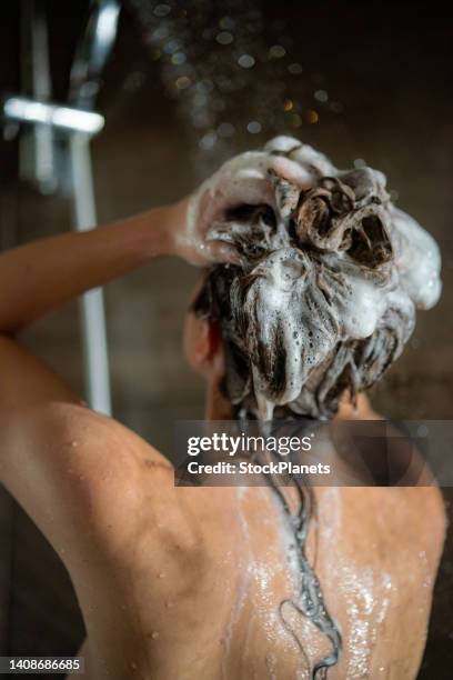 woman washing hair with shampoo - shampoo stockfoto's en -beelden