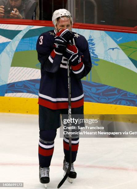 S Jack Johnson watches Canada celebrate its win after beating the Americans in overtime, 3-2, in the gold medal hockey game at the Winter Olympic...