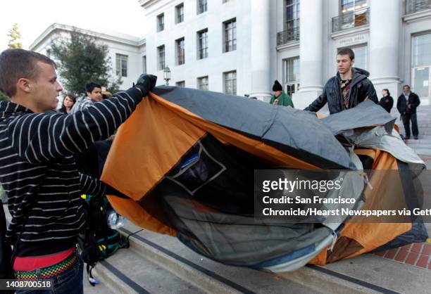 Daniel Heckman and Valle Rogers flod up a tent after a police order at the Occupy Cal camp on the steps of Sproul Hall at UC Berkeley on Thursday,...