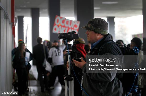 Video blogger Spencer Mills streams live an Occupy Oakland action against a Bank of America branch in Oakland, Calif. On Wednesday, Feb. 29, 2012....