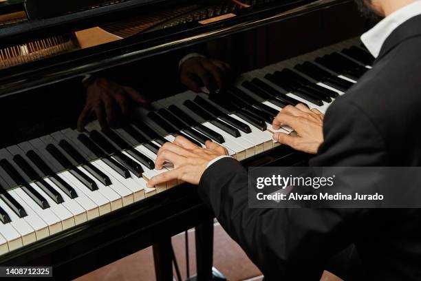 close up shot of an unrecognizable elegant pianist in a suit playing a grand piano. - pianist stock pictures, royalty-free photos & images