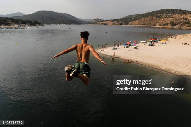 Man jumps into the water as he attempts to cool off at San Juan Swamp in Pelayos de la Presa as temperatures continue to soar on July 14, 2022 in...