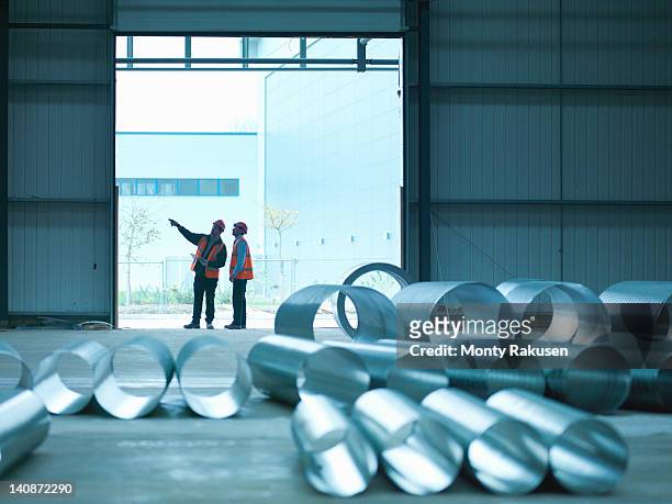 foreman and apprentice in doorway in factory of building site - construction material ストックフォトと画像