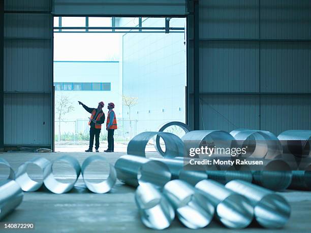 foreman and apprentice in doorway in factory of building site - steel production imagens e fotografias de stock