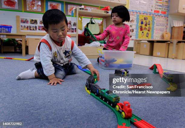 David Zhu and Cathy Zeng play with a train set at Chinatown's Little Sprouts Child Development Center in San Francisco, Calif. On Wednesday, June 12,...