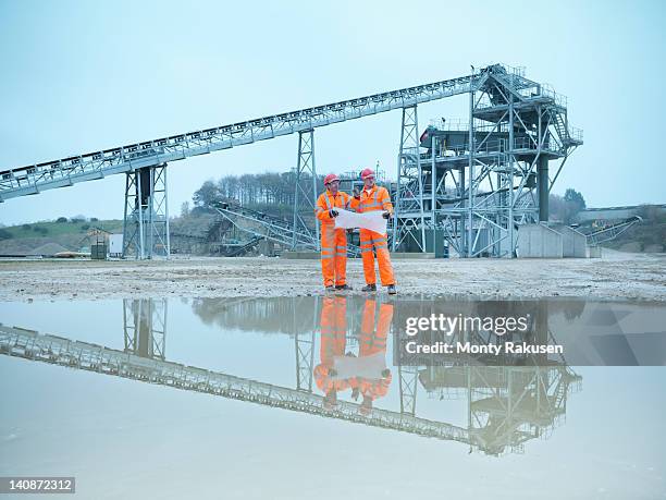 quarryman and assistant looking at plans in front of quarry screening plant - screening of england is mine stock pictures, royalty-free photos & images