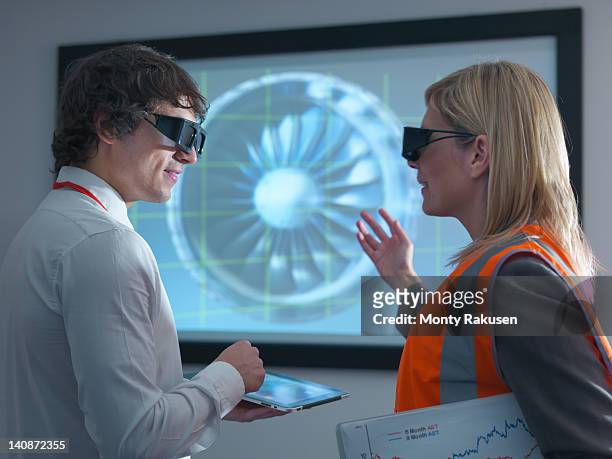 engineer and apprentice in 3d glasses discussing engine on 3d screen - virtual reality simulator presentation stockfoto's en -beelden