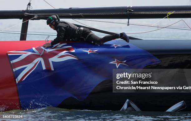 Crew member straddles the hull during a training session by Emirates Team New Zealand in San Francisco, Calif. On Tuesday, July 2, 2013. Competition...
