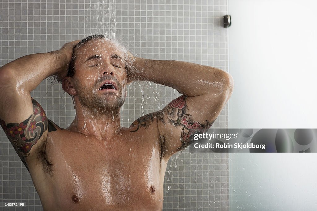 Man washing his hair in shower