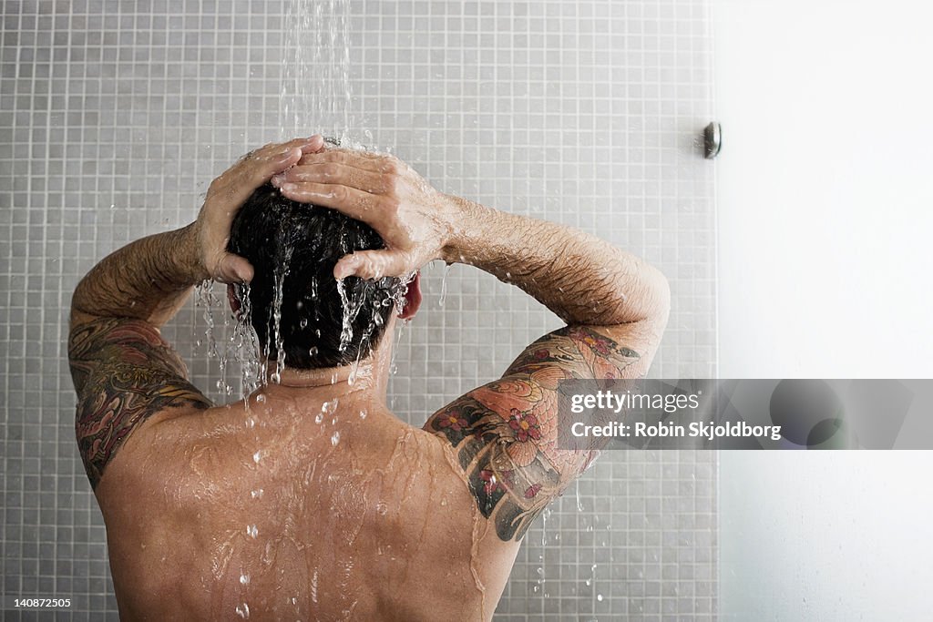 Man washing his hair in shower