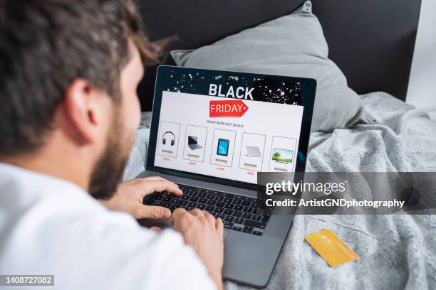 man online shopping for electronics on sale.black friday sale. - black friday shoppers stockfoto's en -beelden