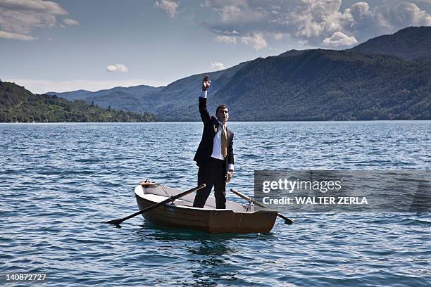 businessman calling for help in rowboat - rowboat stock pictures, royalty-free photos & images