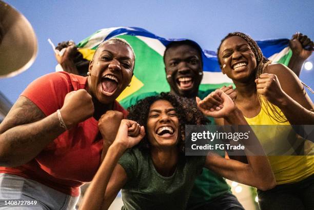 portrait of friends celebrating with south african flag outdoors - mens world championship stock pictures, royalty-free photos & images